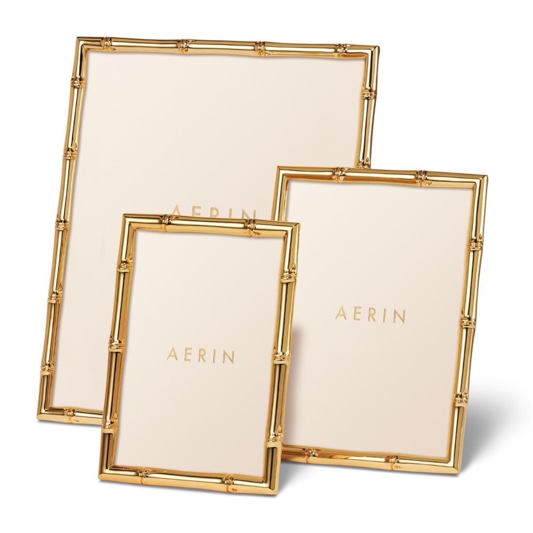 The Ava Bamboo Frame Collection by Aerin includes three gold-finished bamboo-style frames in varying sizes, each featuring a blank insert with the Aerin brand name in gold text.