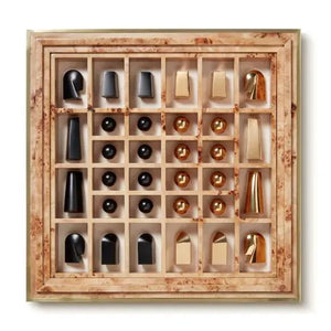 The Aerin Shagreen Chess Set Collection features gold-plated abstract chess pieces on a beige and brown marble board with a grid layout, all presented in a luxurious shagreen box.