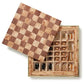 The Aerin Shagreen Chess Set Collection features a wooden chessboard that slides open to reveal gold-plated pieces, all neatly arranged in compartments within a luxurious shagreen box.