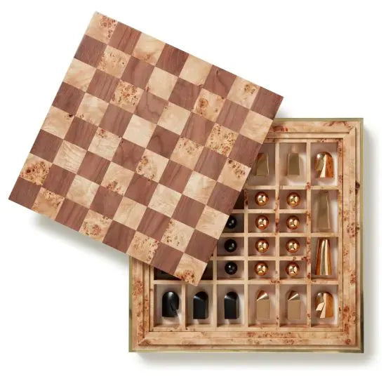 The Aerin Shagreen Chess Set Collection features a wooden chessboard that slides open to reveal gold-plated pieces, all neatly arranged in compartments within a luxurious shagreen box.