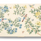 The AERIN x Gracie Heathcote Lacquer Backgammon Set features a Heathcote design with birds, butterflies, and blue and yellow flowers on branches against a cream background.