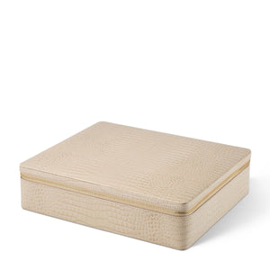 The Enzo Travel Mahjong Set in Fawn by Aerin is a closed, rectangular box with a beige textured Italian leather finish and gold zipper, shown resting on a white background.