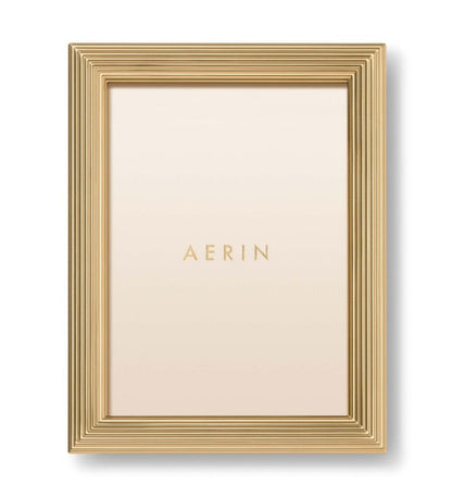 The Alessio Frame Collection by Aerin features a gold rectangular frame with a reeded border, shown vertically with a blank insert reading "AERIN"—a stylish choice for elegant photograph display.