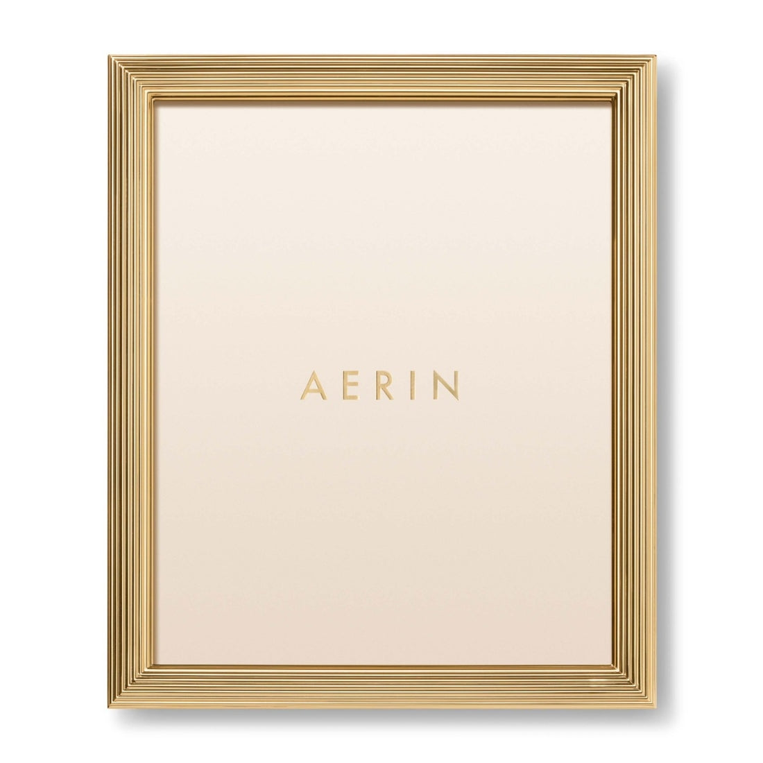 The Alessio Frame Collection by Aerin features a gold reeded rectangular design, with "AERIN" in gold on a cream background—ideal for elegantly displaying your favorite photos.