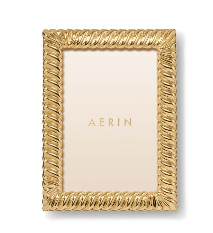 Rectangular gold Loretta Frame from Aerin with a twist design and cream-colored insert labeled "AERIN"—an elegant way to display photos.