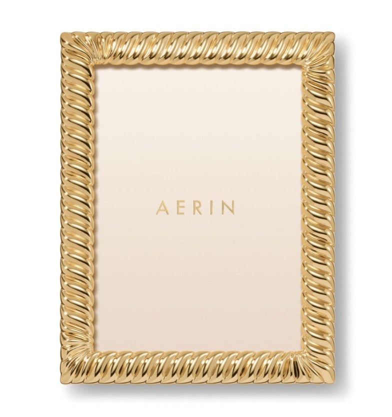 The Loretta Frame Collection by AERIN features a gold twist design with the brand name centered on a light background, offering an elegant way to display your photos.