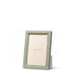 The Piero Leather Frame Collection by Aerin features a vertical green leather frame with gold accents and a gold inner border, displaying an "AERIN" placeholder card against a white background for an elegant touch.
