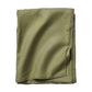 A neatly folded olive green linen napkin from the Juliska Berry Scallop Napkin & Tablecloth Collection, featuring stitched edges and displayed on a white background.