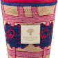 A decorative Baobab collection basket with a pink and navy blue braided design and textured patterns, featuring a gold label with a Baobab Frida Draozy candle emblem.