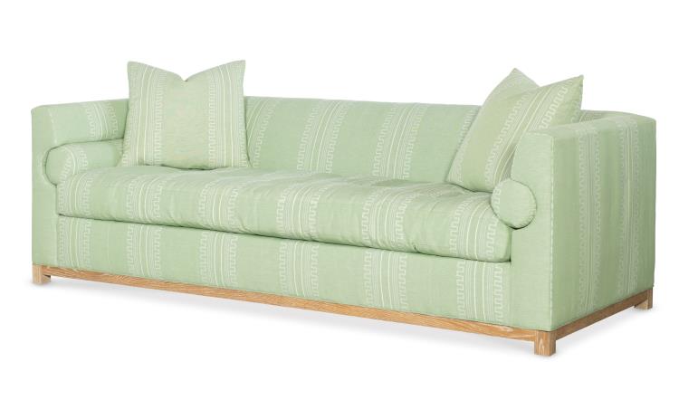 Highland House Barrow Sofa in light green with Green Greco Stripe upholstery features two square pillows, two cylindrical bolsters, a subtle geometric pattern, and a wooden base.