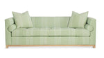 Highland House Barrow Sofa in light green upholstery includes two decorative pillows, features a subtle geometric pattern, and stands on light wooden legs.