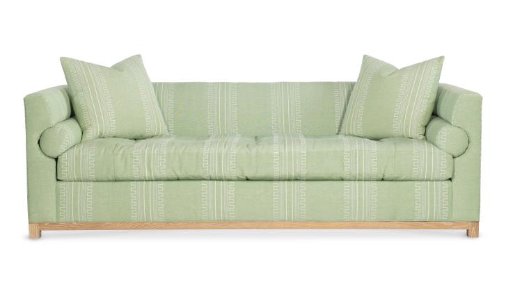 Highland House Barrow Sofa in light green upholstery includes two decorative pillows, features a subtle geometric pattern, and stands on light wooden legs.