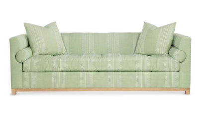 Highland House Barrow Sofa in light green upholstery includes two decorative pillows, features a subtle geometric pattern, and stands on light wooden legs.