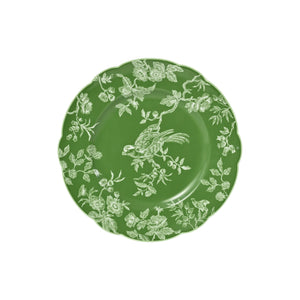 The Albertine Collection by Bernardaud features a green ceramic plate with scalloped edges, decorated with white floral and bird patterns reminiscent of toile de Jouy, shown from above on a white background.