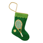 The Bauble Stockings Tennis Green Needle Point Stocking features a hand-stitched tennis racket and ball design with a gold hanging loop.