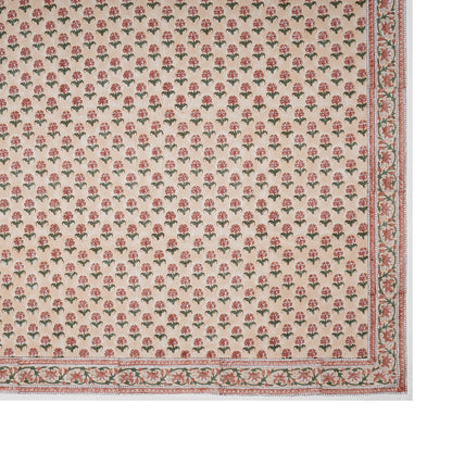 Rectangular area rug with a beige background, red and green floral motifs, and a decorative border—perfect for pairing with the Alwar Table Linen Collection from SLOANE BY HAND.