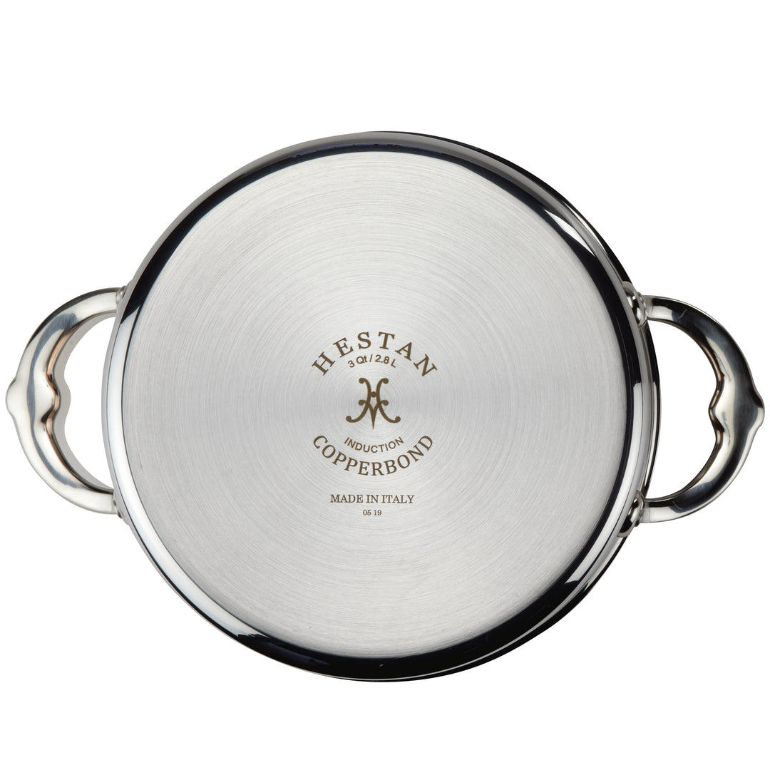 The Hestan CopperBond Copper Induction Soup Pot, 3qt is shown from the bottom with side handles and product details engraved at the center.