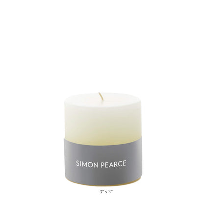 Ivory Candle Collection by Simon Pearce—an artisan, small-batch candle featuring a gray brand label. Perfect for bringing warmth and elegance to your home. Candle dimensions: 3" x 3". Photographed against a plain white background.