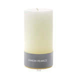 An ivory pillar candle from the Simon Pearce Ivory Candle Collection stands upright on a plain white background—an artisan creation crafted in small batches to enhance any home.