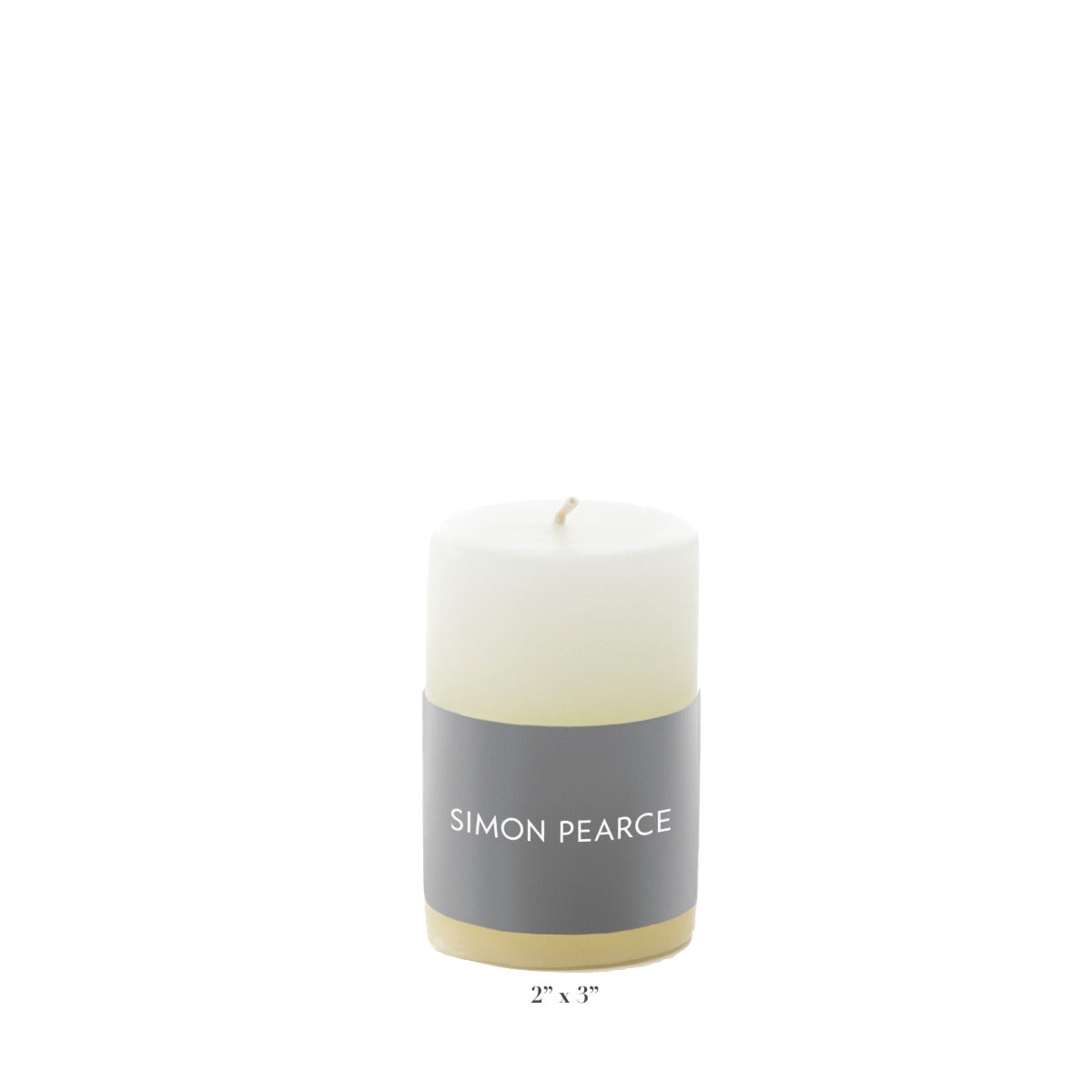 The Simon Pearce Ivory Candle Collection features a white pillar candle with a gray label, measuring 2" x 3". This artisan piece adds understated elegance to your home decor.