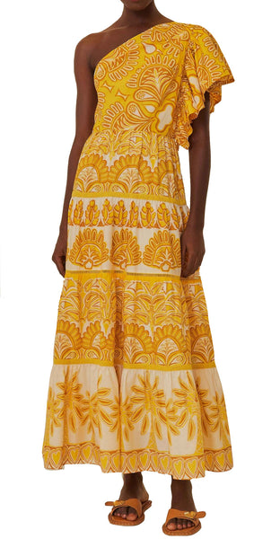 Woman in a Farm Rio Yellow Ainika Tapestry One Shoulder Maxi Dress with tiered skirt, paired with brown sandals, against a plain background.
