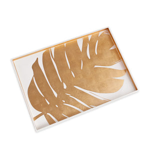 The Beatriz Ball Large Lacquered Philodendron Tray is a rectangular white serving tray with a bold gold philodendron leaf, perfect as a decorative accent or coffee table tray to add a touch of elegance to any space.