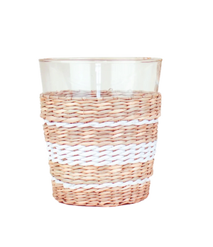 The Be Home Seagrass White Stripe Glassware Collection features clear glass tumblers wrapped in light brown seagrass with white stripes—ideal for pairing with your favorite table linens.