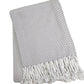 A Soft Idea Nantucket Herringbone Throw Collection in Pearl Grey, featuring a folded grey and white design with hand-knotted fringe, shown on a white background.