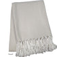 The Nantucket Herringbone Throw Collection by A Soft Idea in Sand features a beige and white cotton throw with hand-knotted fringe, folded neatly.