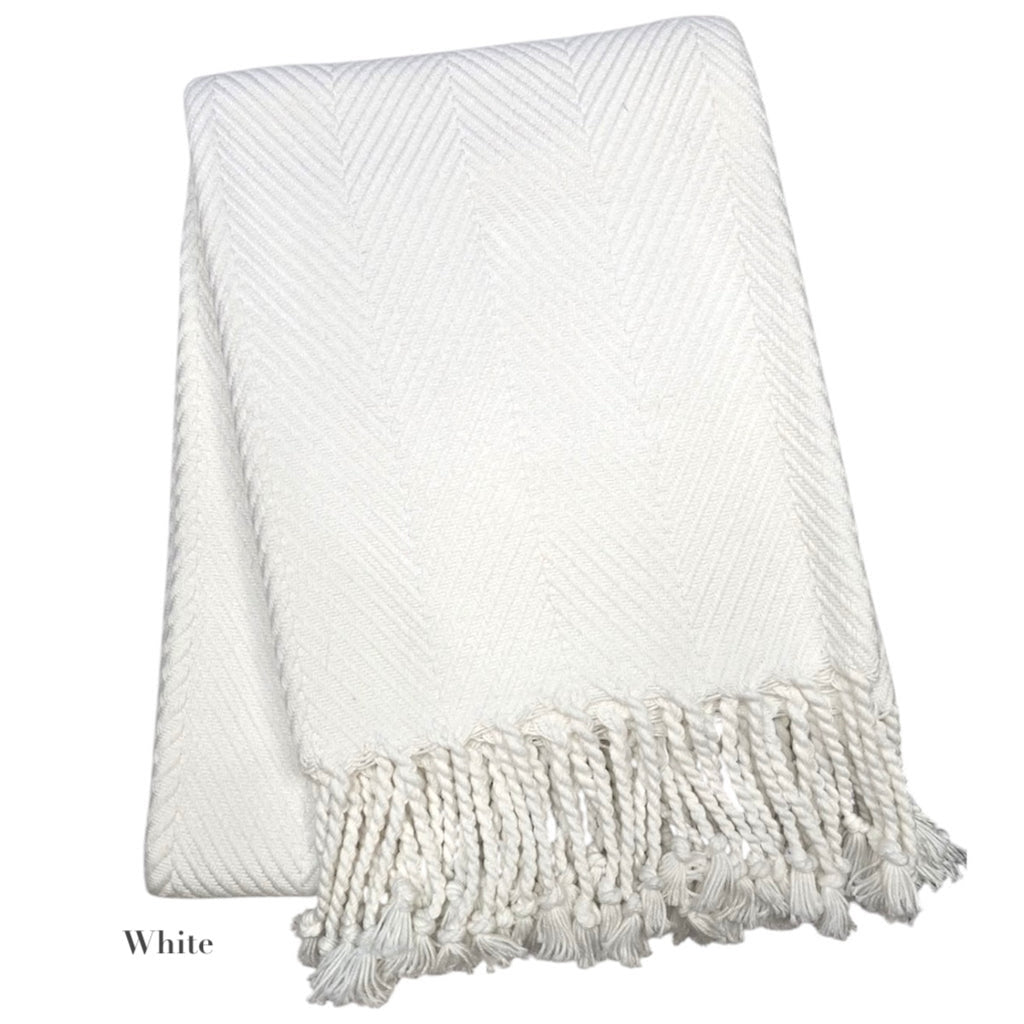 The Nantucket Herringbone Throw Collection by A Soft Idea features crisp white cotton, a subtle pattern, and elegant hand-knotted fringe along one edge.