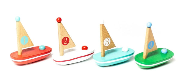 Four colorful Jack Rabbit Creation My Lil' Wooden Sailboats numbered 1 through 4, designed to float and spark imagination, arranged in a row on a white background.