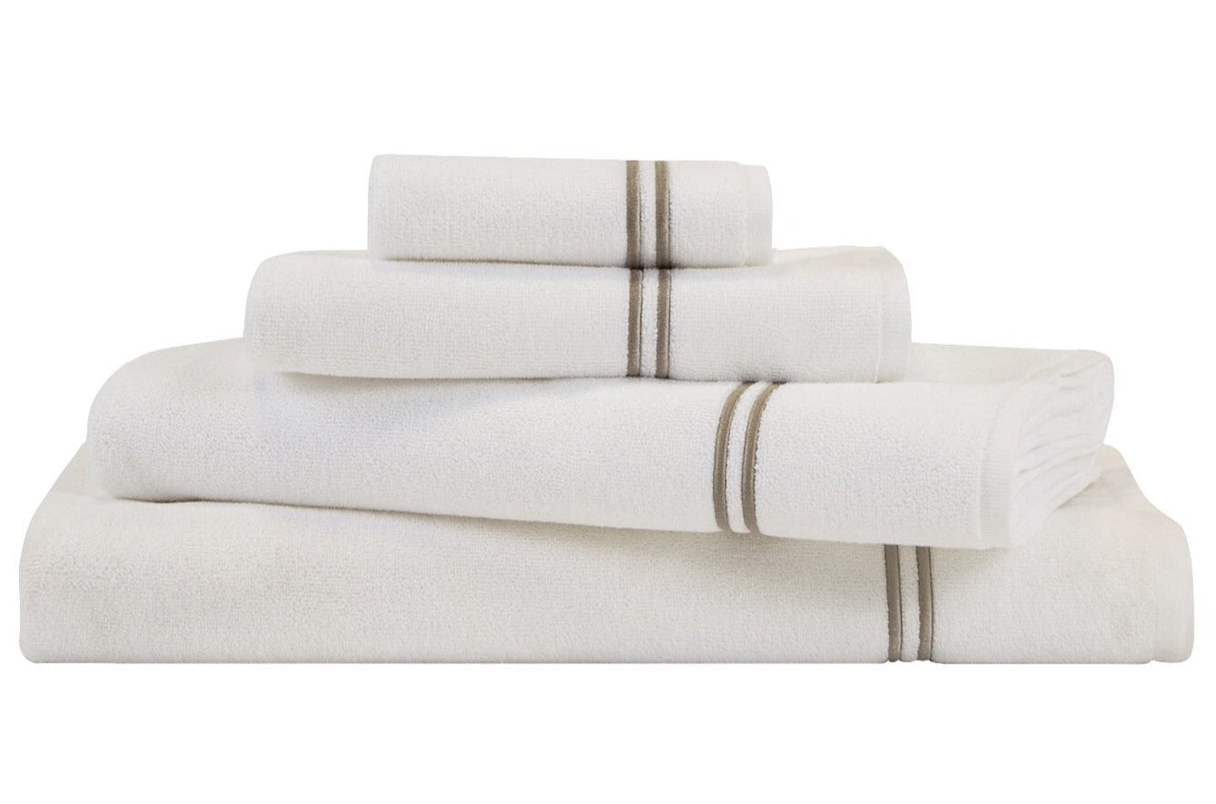 A neatly stacked set from the Frette Classic White/Khaki Bath Collection features cotton terry towels with thin khaki stripes, arranged from largest to smallest—an elegant addition to any bathroom décor.