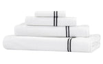 A stack of four Frette Classic White/Grey Bath Collection cotton terry towels, each featuring one or two grey stripes near the edge, arranged against a white background—perfect for elevating your bathroom experience.