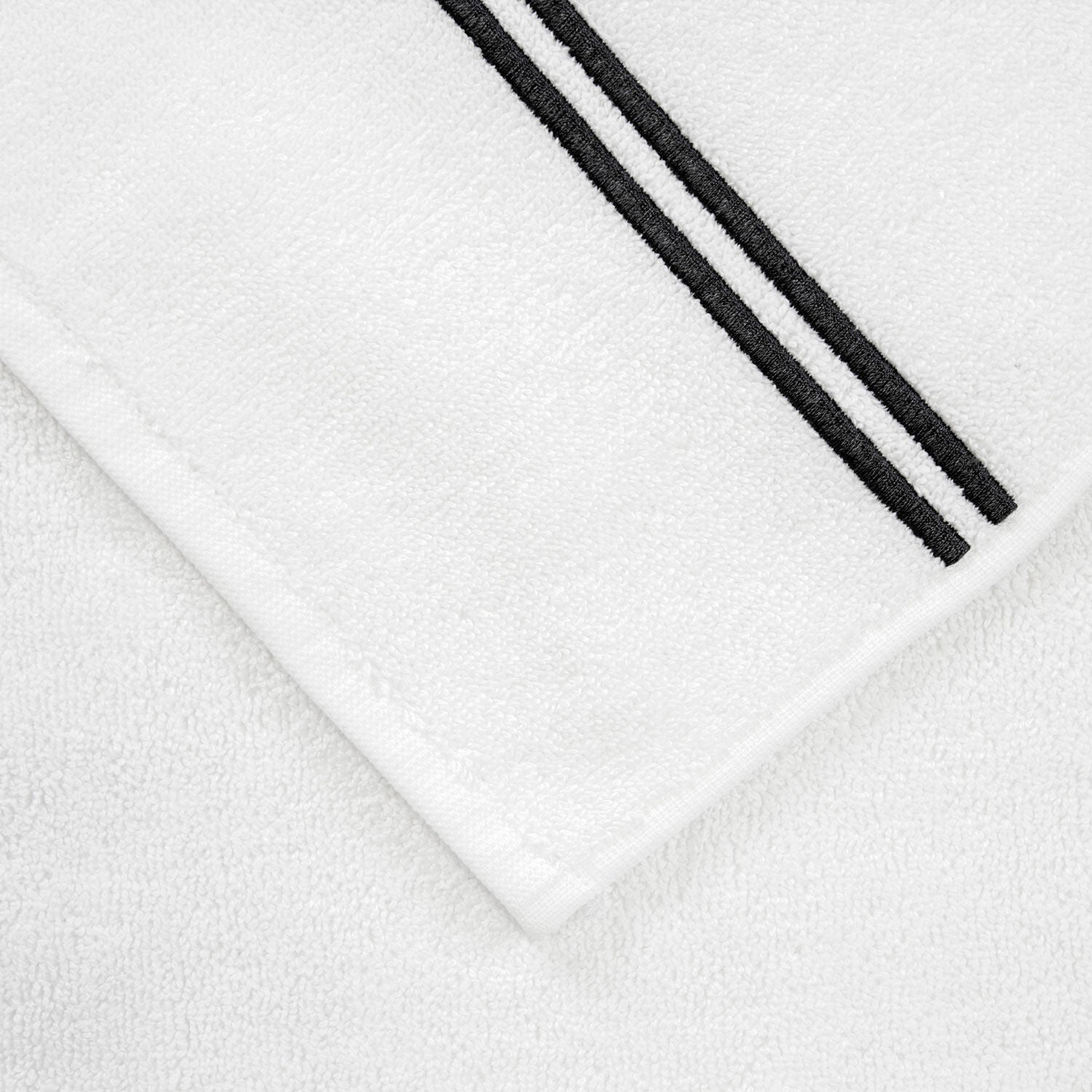 The Frette Classic White/Grey Bath Collection features a white cotton terry towel with two parallel black stripes along one edge, elevating your bathroom experience.