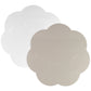 Two placemats from the Addison Ross Scalloped Lacquer Placemat Collection, one white and one beige, with flower-shaped scalloped edges and a subtle velvet embossed texture, are placed side by side on a plain background.