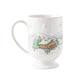 The Juliska Berry & Thread North Pole Collection includes a white ceramic mug with a pedestal base, featuring a winter cabin scene—perfect for pairing with your favorite Christmas or reindeer dinnerware this holiday season.