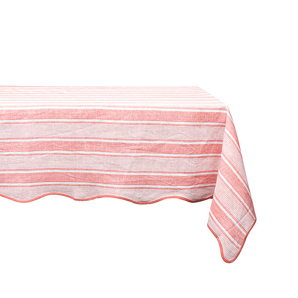 A rectangular table covered with a breezy linen tablecloth from the Juliska Cabana Stripe Collection, featuring red and white stripes, is elegantly positioned against a stark white background.