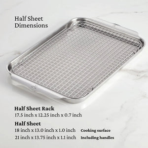 The Hestan Provisions OvenBond Tri-ply 3-Piece Set, featuring a warp-resistant half sheet pan and stainless steel rack with listed dimensions, rests on a marble surface.