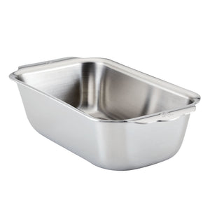 The Hestan Provisions OvenBond Tri-ply Stainless Steel Loaf Pan, featuring rounded corners and extended handles, is shown on a white background and provides excellent heat conductivity for even baking.