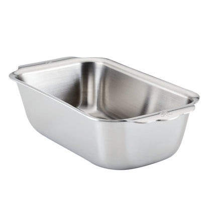 The Hestan Provisions OvenBond Tri-ply Stainless Steel Loaf Pan, featuring rounded corners and extended handles, is shown on a white background and provides excellent heat conductivity for even baking.