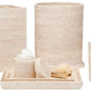 The Dalton Bath Collection by Pigeon & Poodle features a matching set of handmade woven beige rattan bathroom accessories: waste bin, tissue box cover, soap dispenser, tray, and storage containers.
