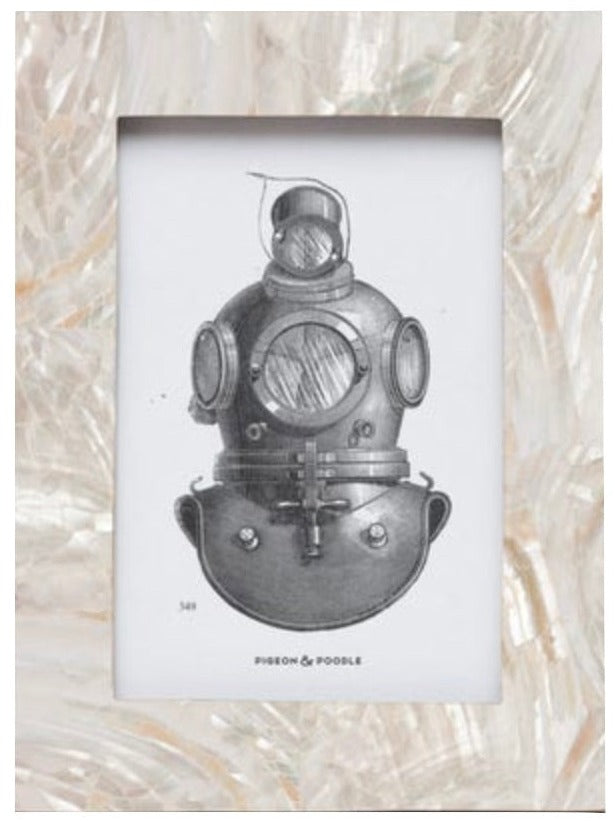 The Pigeon & Poodle Aurora Frame Collection features a framed illustration of a vintage deep-sea diving helmet set against a textured, pearl-inspired background and encased in an iridescent shell-accented frame.