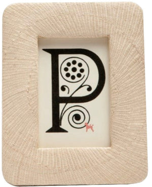 Part of the Pigeon & Poodle Ancona Frame Collection, this framed artwork displays a large ornate "P" with black patterns inspired by spiral buntal weave and a small red dog at the bottom right, reflecting unique craftsmanship.