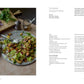 A plate of Lebanese chopped salad with herbs and onions rests on a cutting board beside a knife, set atop a marble surface—an ideal creation from A Meal For Two by Chronicle Books. The recipe’s ingredients and instructions appear on a page to the right, making this vibrant salad an excellent choice for quick 15-minute meals.