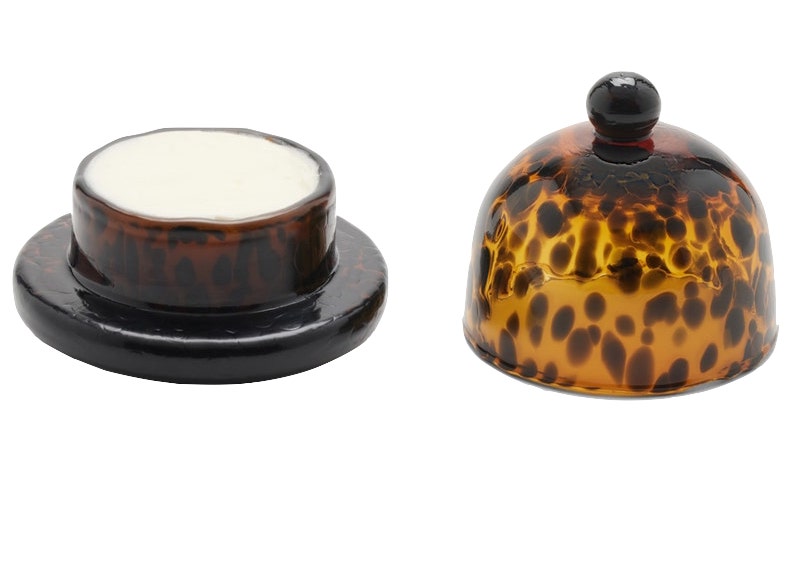 The Blue Pheasant Andrew Tortoise Butter Dish is a durable hand-blown glass set with a tortoiseshell pattern, featuring a round base for butter and a matching dome lid displayed beside it.