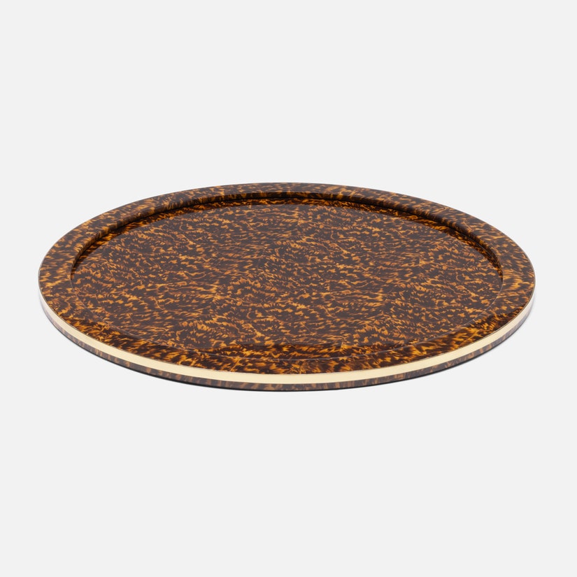 The Maximilian Bar Collection tray by Blue Pheasant features a round, flat shape with a brown and yellow faux tortoise shell pattern and a thin beige rim—ideal for showcasing vintage barware or your favorite cocktail shaker.