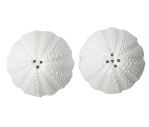The Marina White Salt and Pepper Shaker Set by Blue Pheasant features two sea urchin-shaped porcelain shakers in white, each viewed from above with holes on top.
