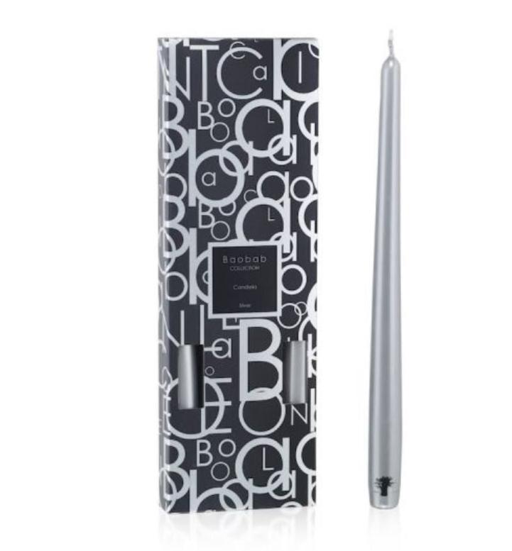 A silver tapered candle is displayed next to its box, adorned with a black and white letter pattern design, ready to elegantly complement any candlestick from the Baobab Collection Candela by Baobab.