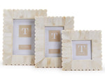 The Bone Scalloped Frame Collection by Two's Company features three cream-colored decorative frames with scalloped edges, displayed upright side by side against a plain white background.