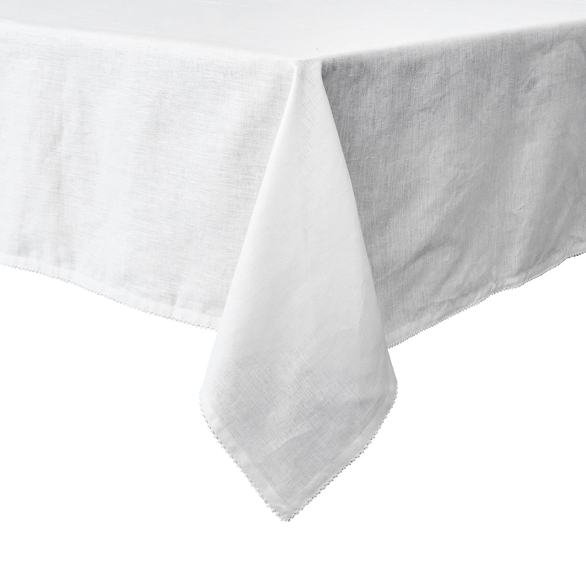 A close-up view of the Juliska Berry Scallop Tablecloth from the Berry Scallop Napkin & Tablecloth Collection, featuring its white woven linen draped over the corner of a rectangular table against a white background.